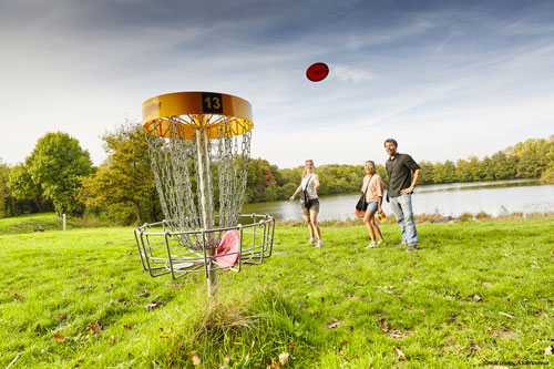 une famille lance un frisbee au parc le grand défi en vendée